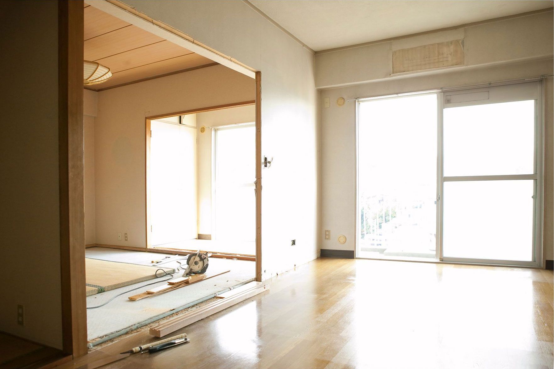 An empty living room with a cat laying on the floor.