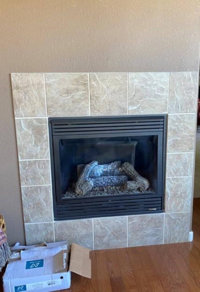 A fireplace with a lot of logs in it is in a living room.