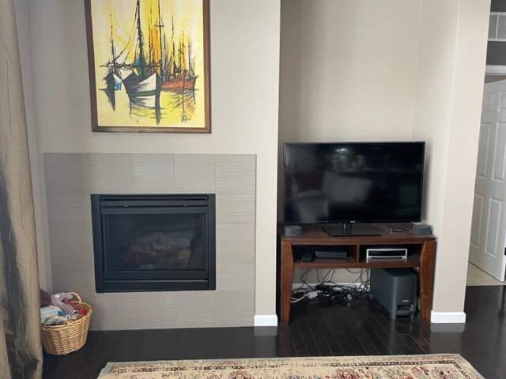 A living room with a fireplace and a flat screen tv