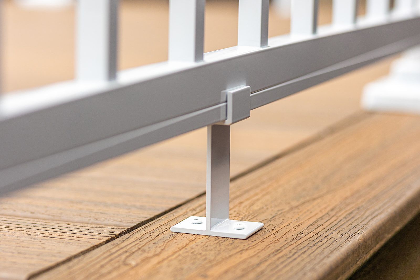 Poteau de rambarde blanc fixé à une terrasse marron.