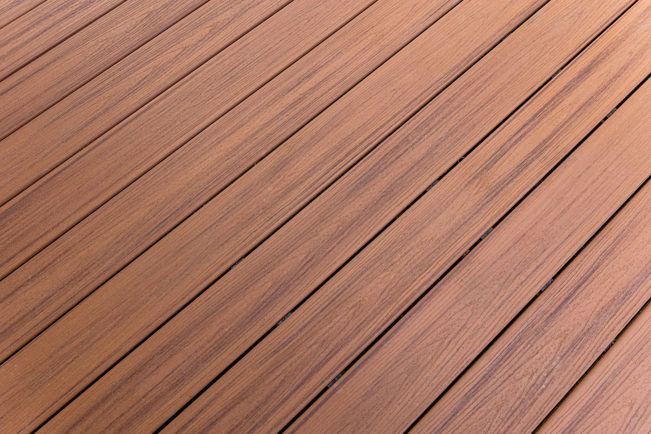 Gros plan sur des planches de bois alignées en diagonale, avec des joints foncés.