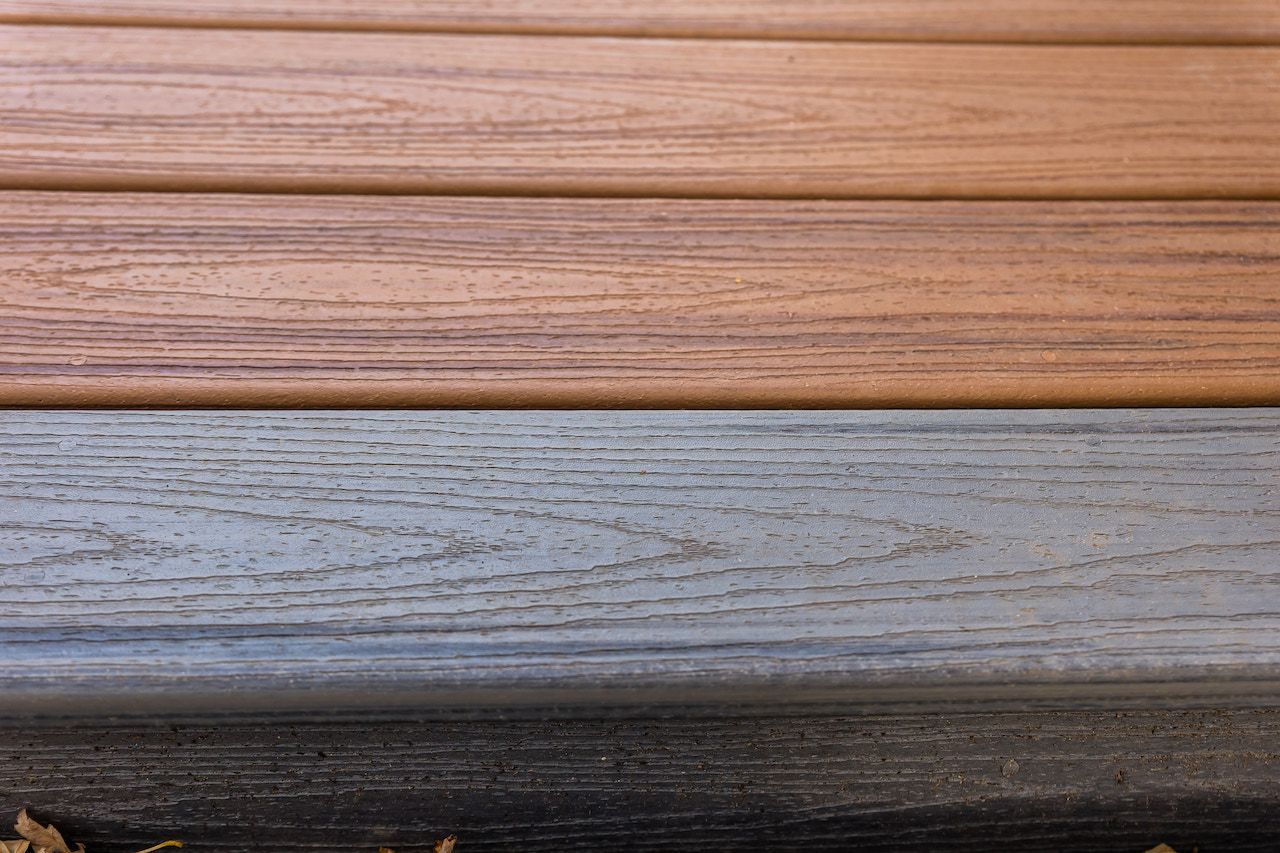 Gros plan sur quatre planches horizontales dans des tons de brun, beige, gris et noir, ressemblant à du bois.