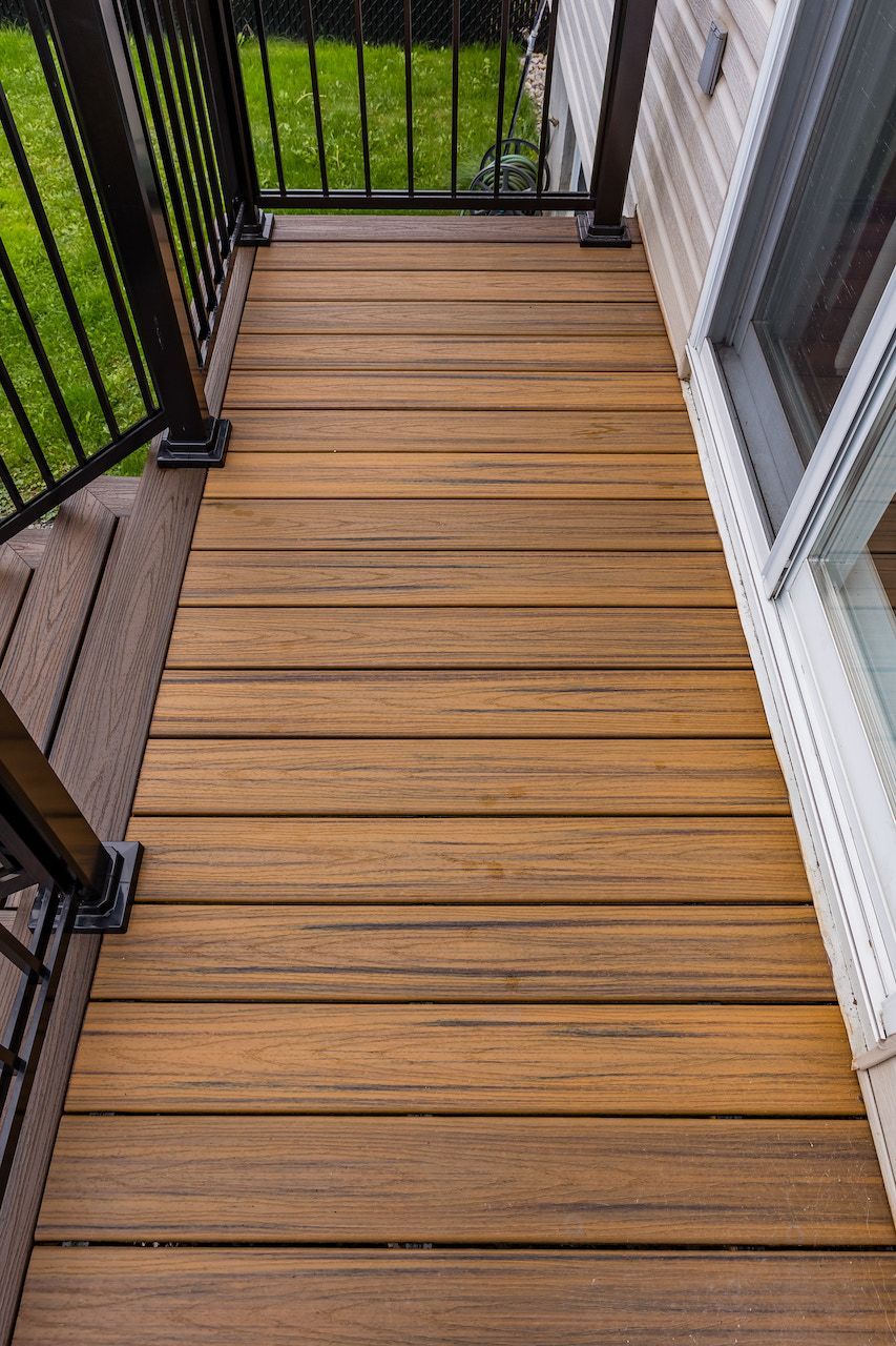 Terrasse en bois avec rambarde et bardage noirs.