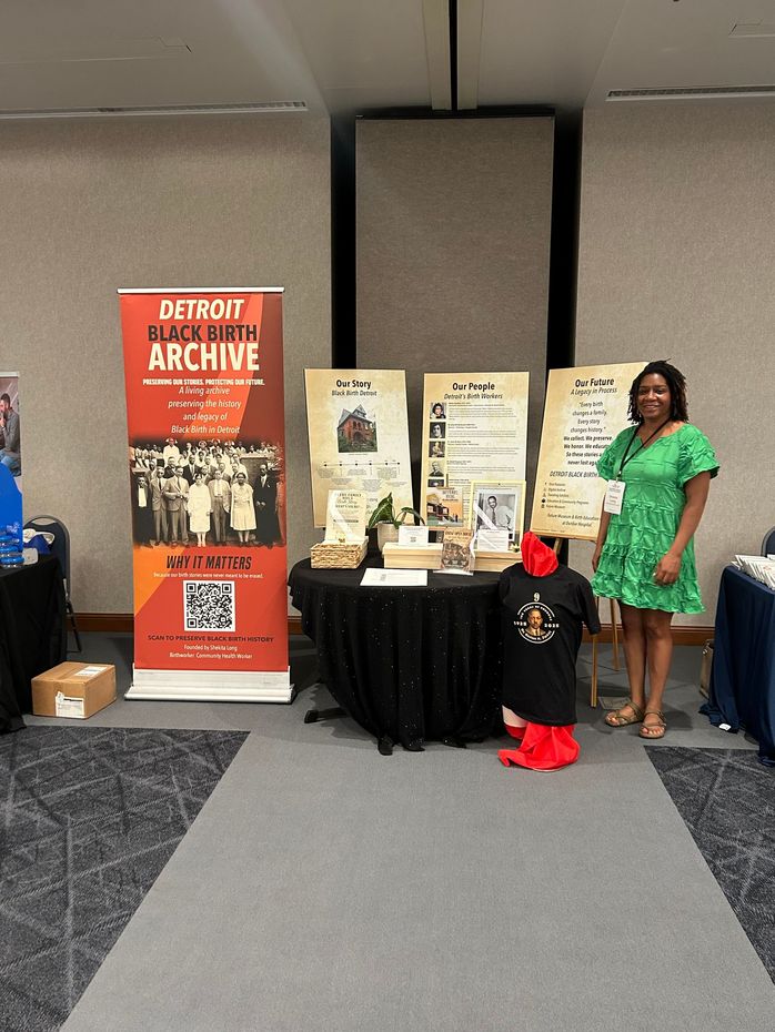 Detroit Black Birth Archive exhibit, featuring historical panels, photographs, archival materials, and a banner