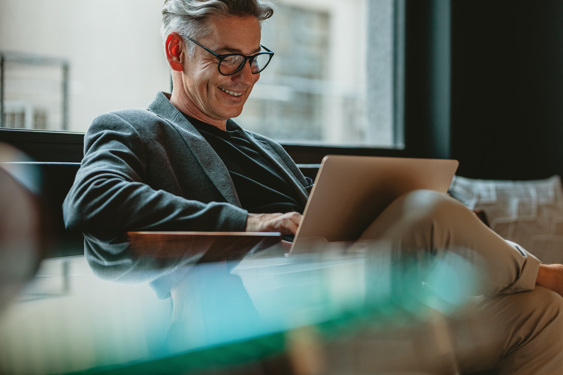 A man is sitting at a table using a laptop computer.