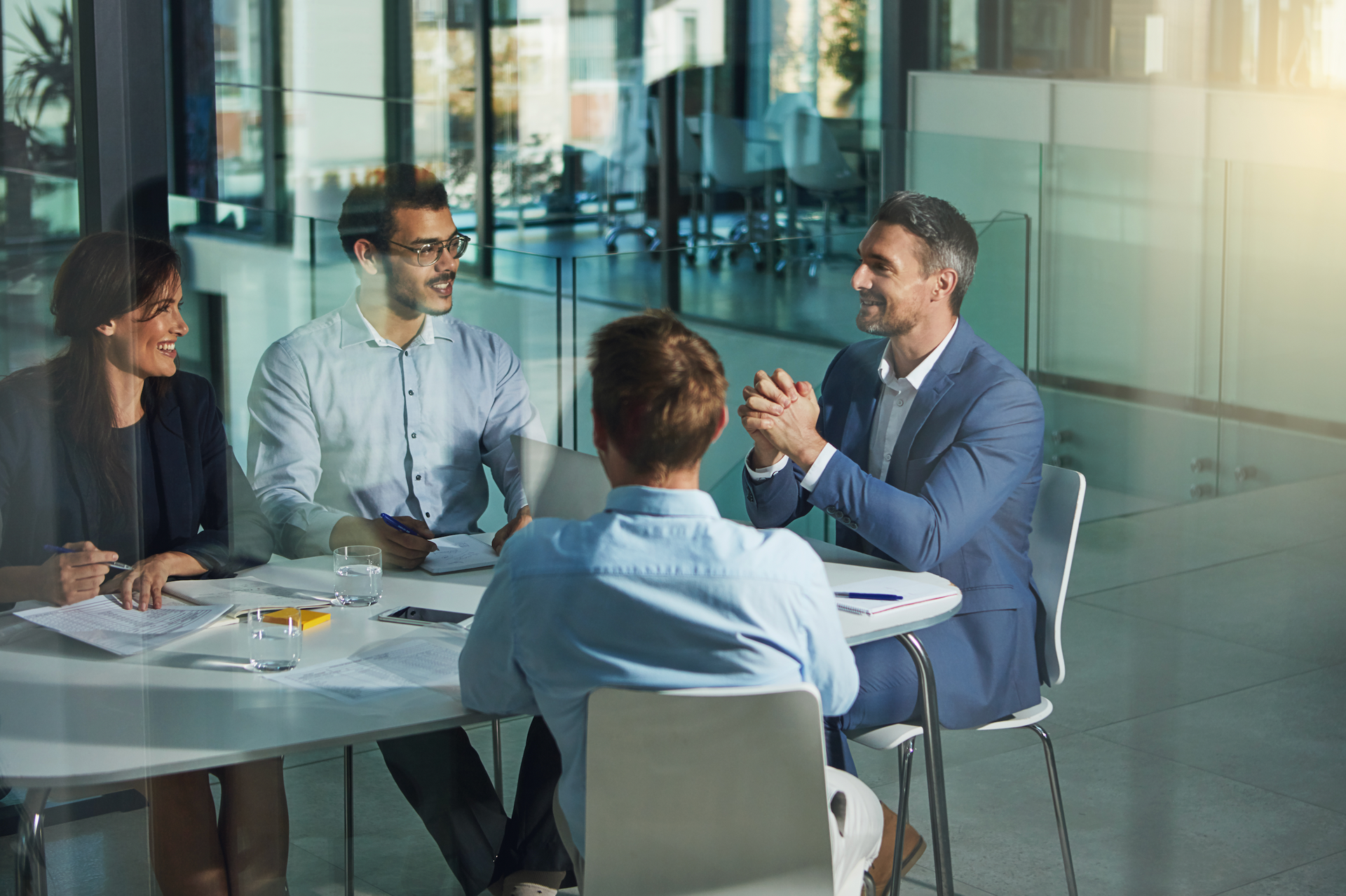 A group of people are sitting around a table having a meeting.