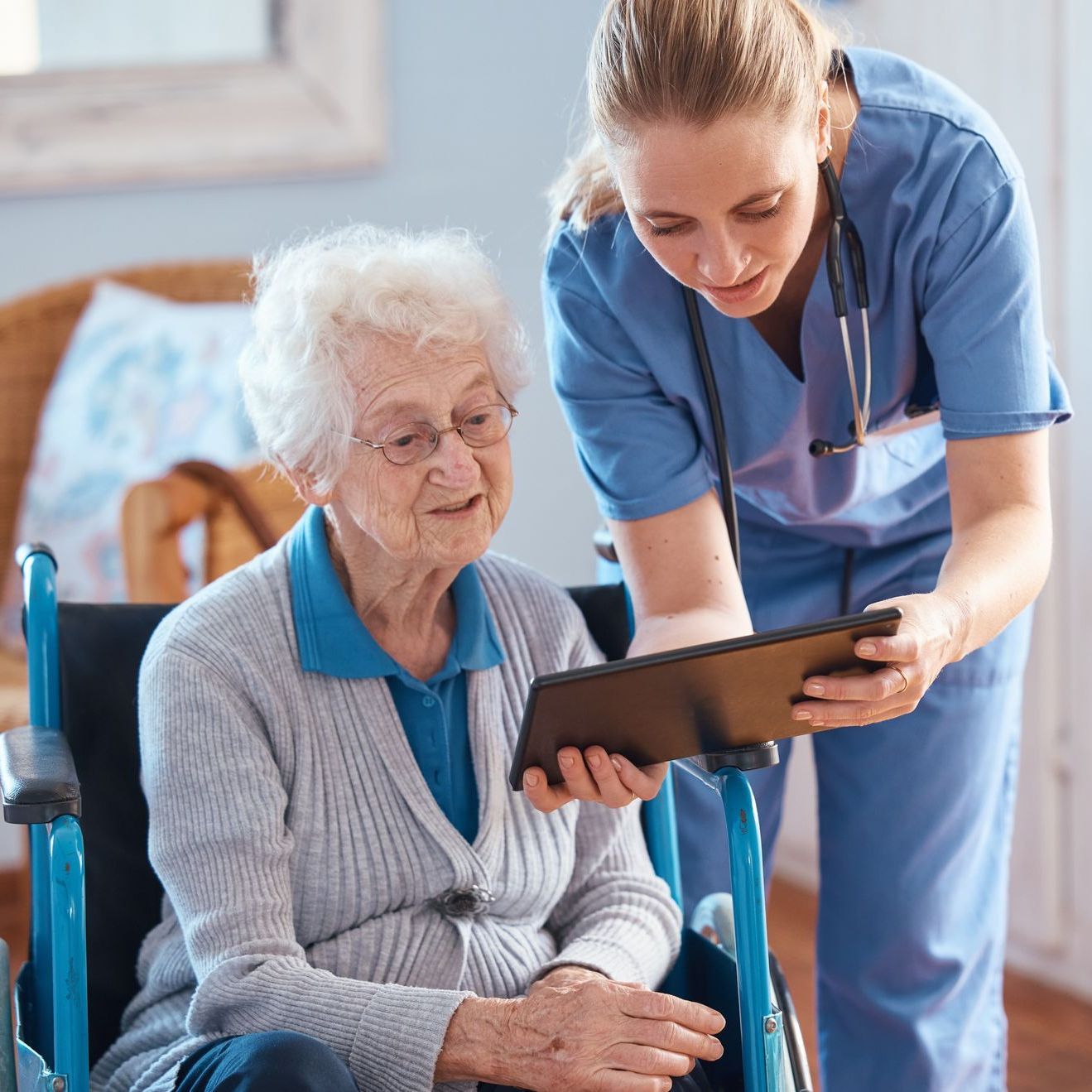 Care worker supporting older woman in care setting