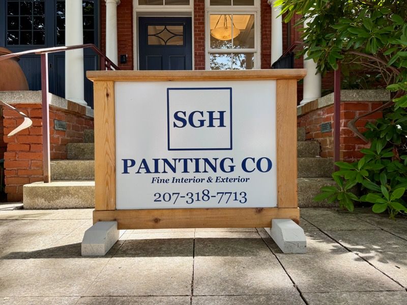 A sign outside a brick building with SGH Painting Co on it.