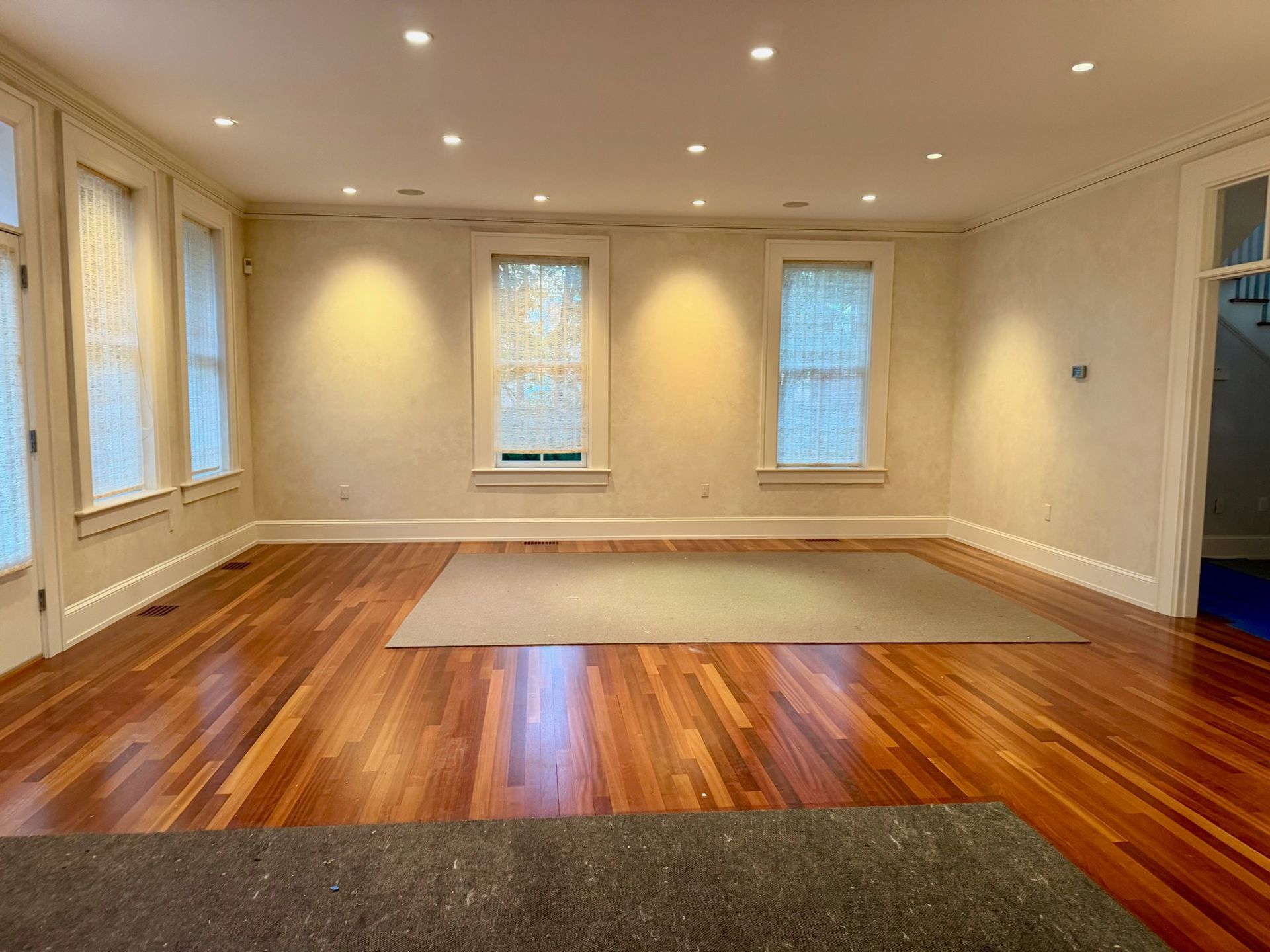 A living room with a christmas tree in it, along with couches and a chandelier