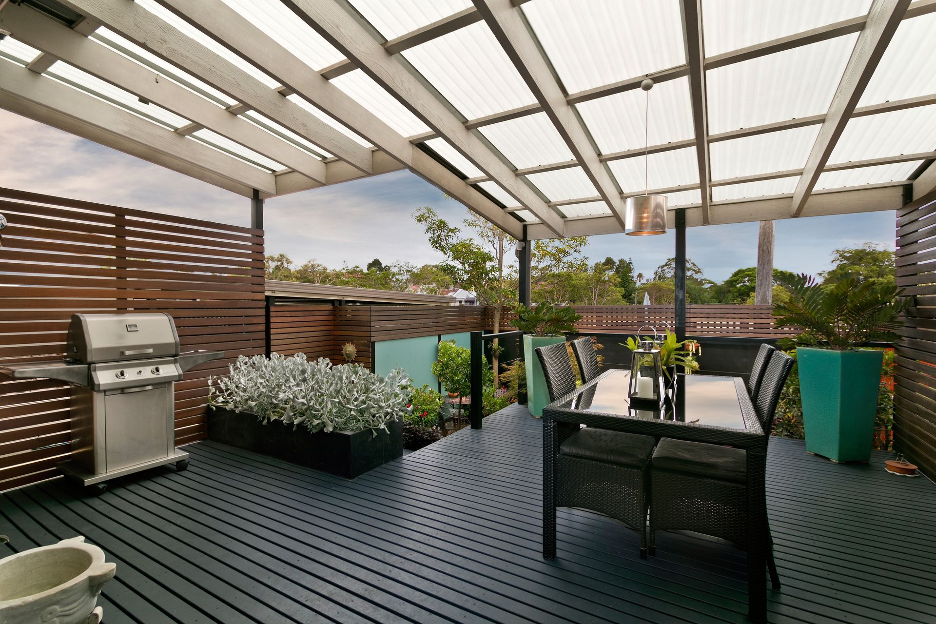 A patio with a table and chairs and a grill