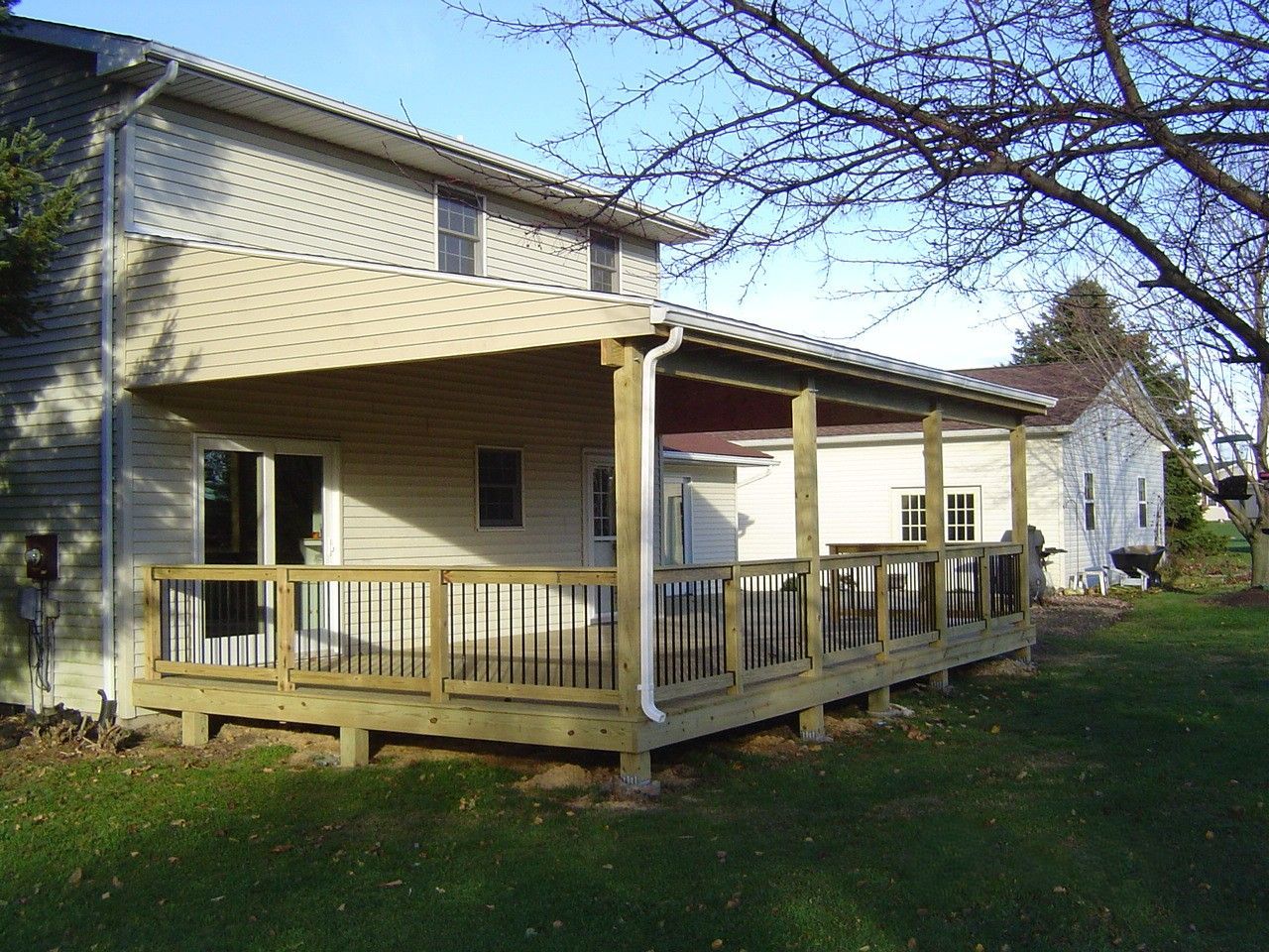 A porch with a couch , chairs , and a ceiling fan.
