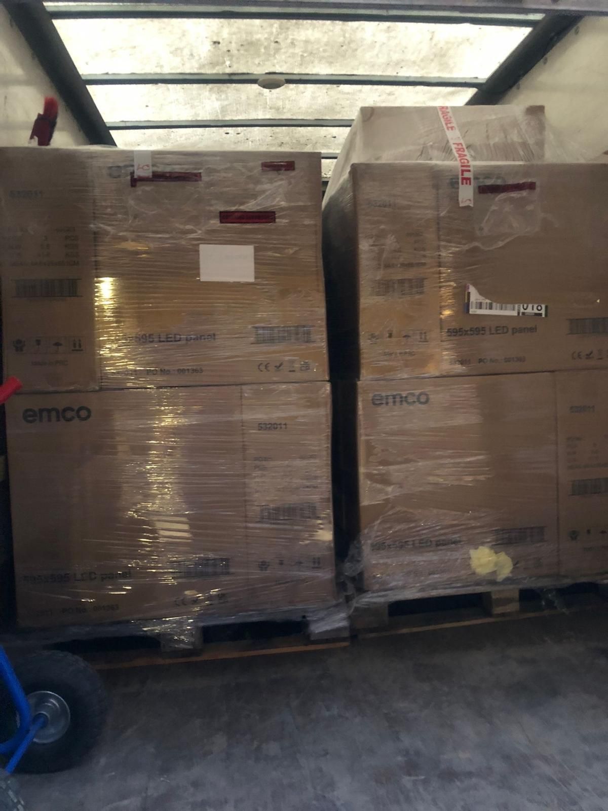 Pallets of boxed goods wrapped in plastic inside a warehouse loading area