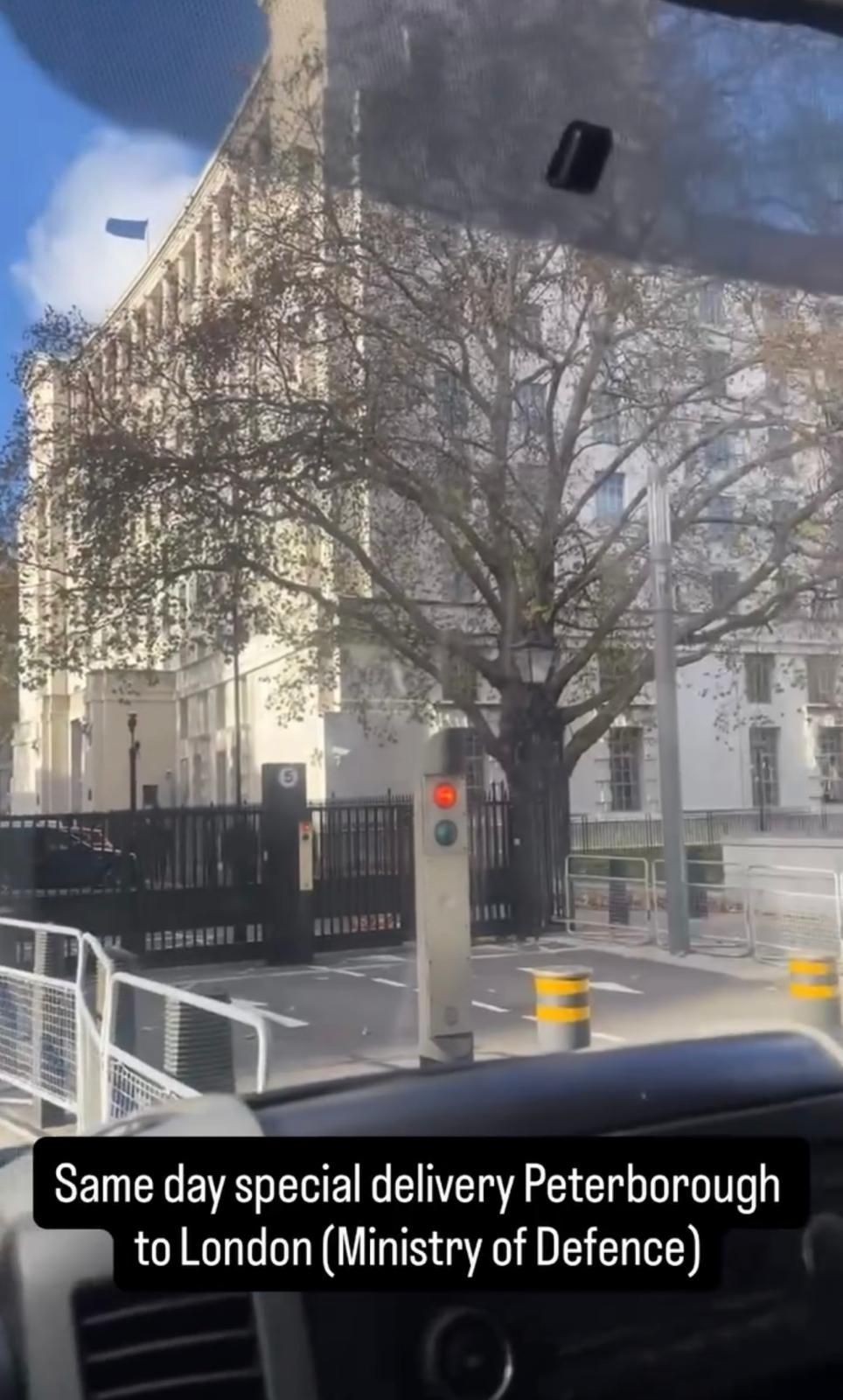 Street view of a London building with a black fence, leafless tree, and caption about same-day delivery to London.