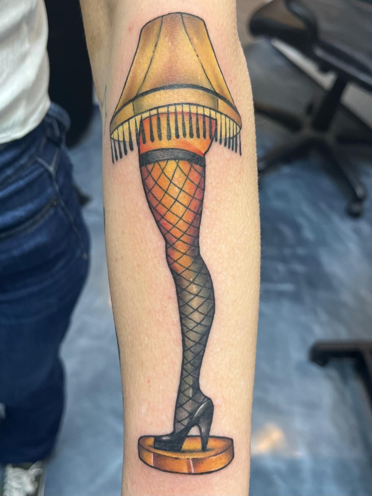 A woman has a tattoo of a lamp on her arm