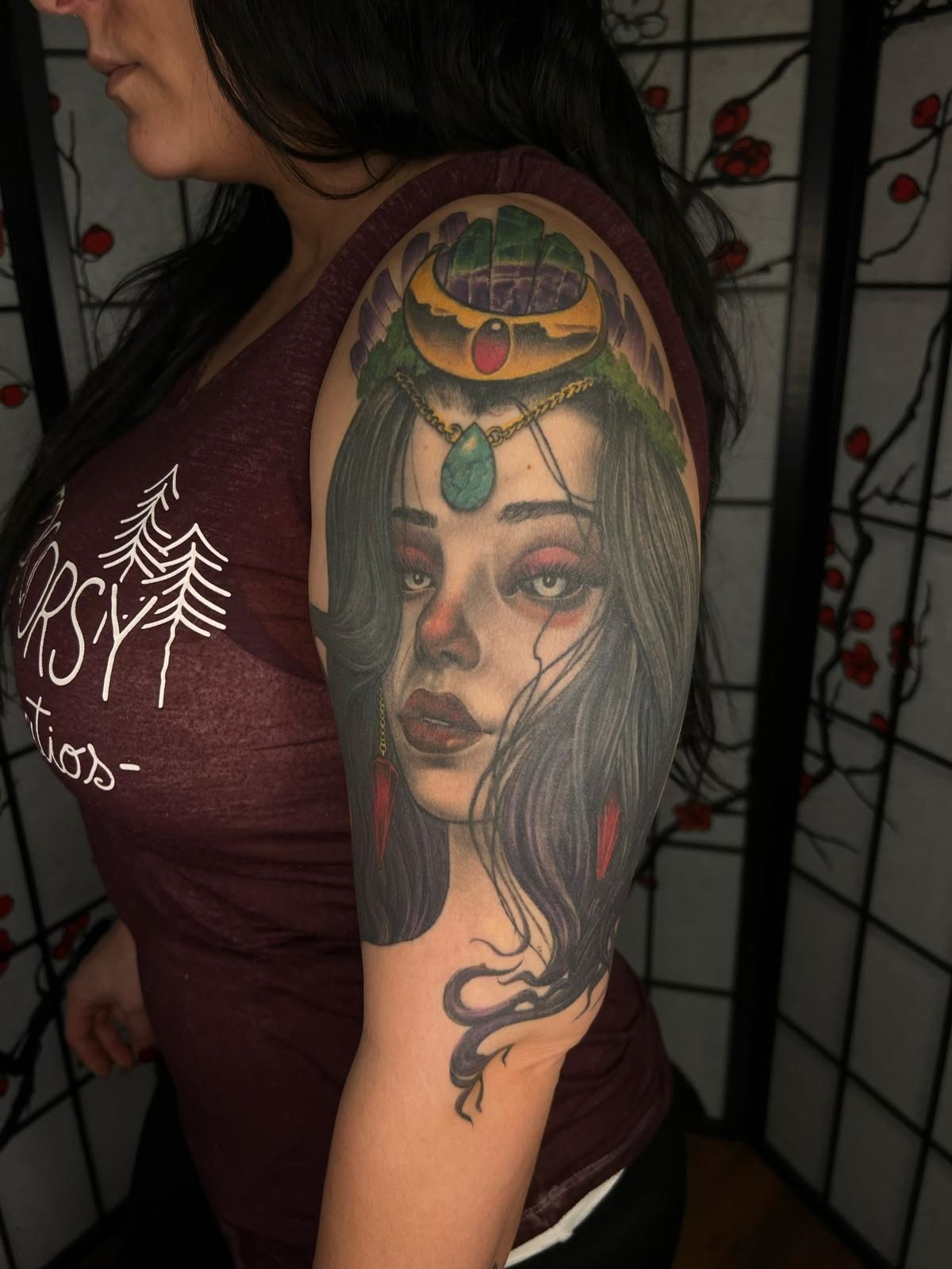 A woman has a tattoo of a woman 's face on her arm