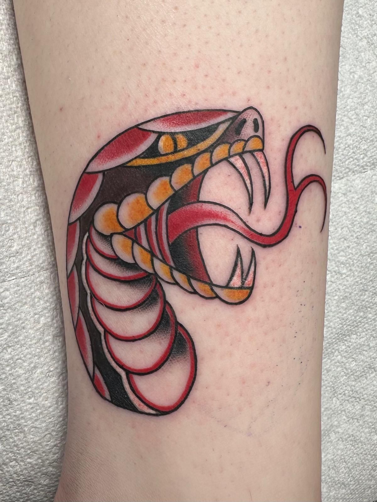 A tattoo of a snake with its tongue hanging out