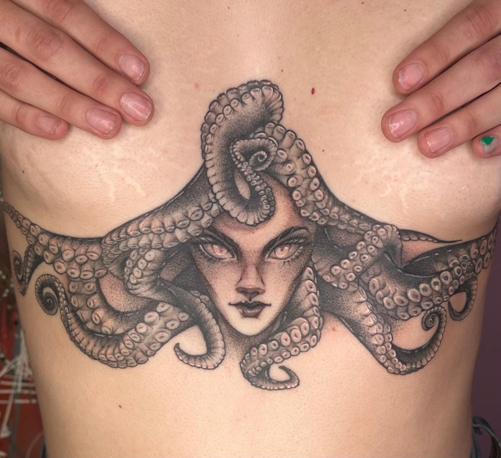 A woman has an octopus tattoo on her chest