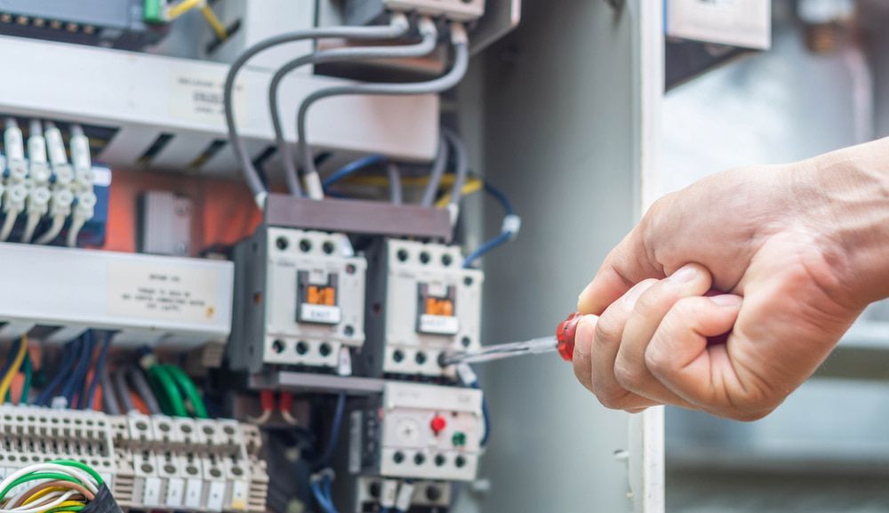A Person is Working on an Electrical Box With a Screwdriver — Russell Taber Electrical & Solar in Lake Albert, NSW