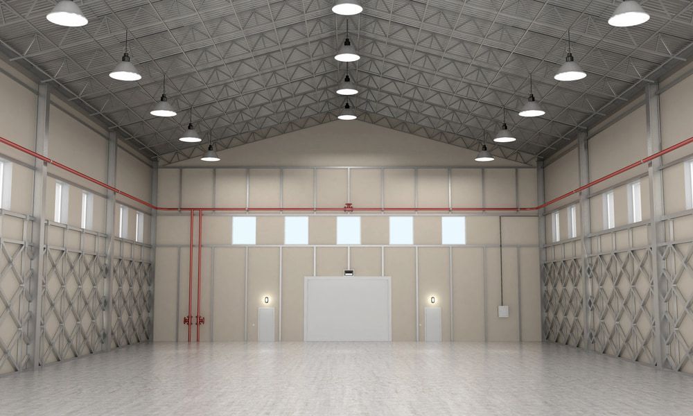 A Large Empty Warehouse With Lots of Windows and Ceiling Lights — Russell Taber Electrical & Solar in Lake Albert, NSW