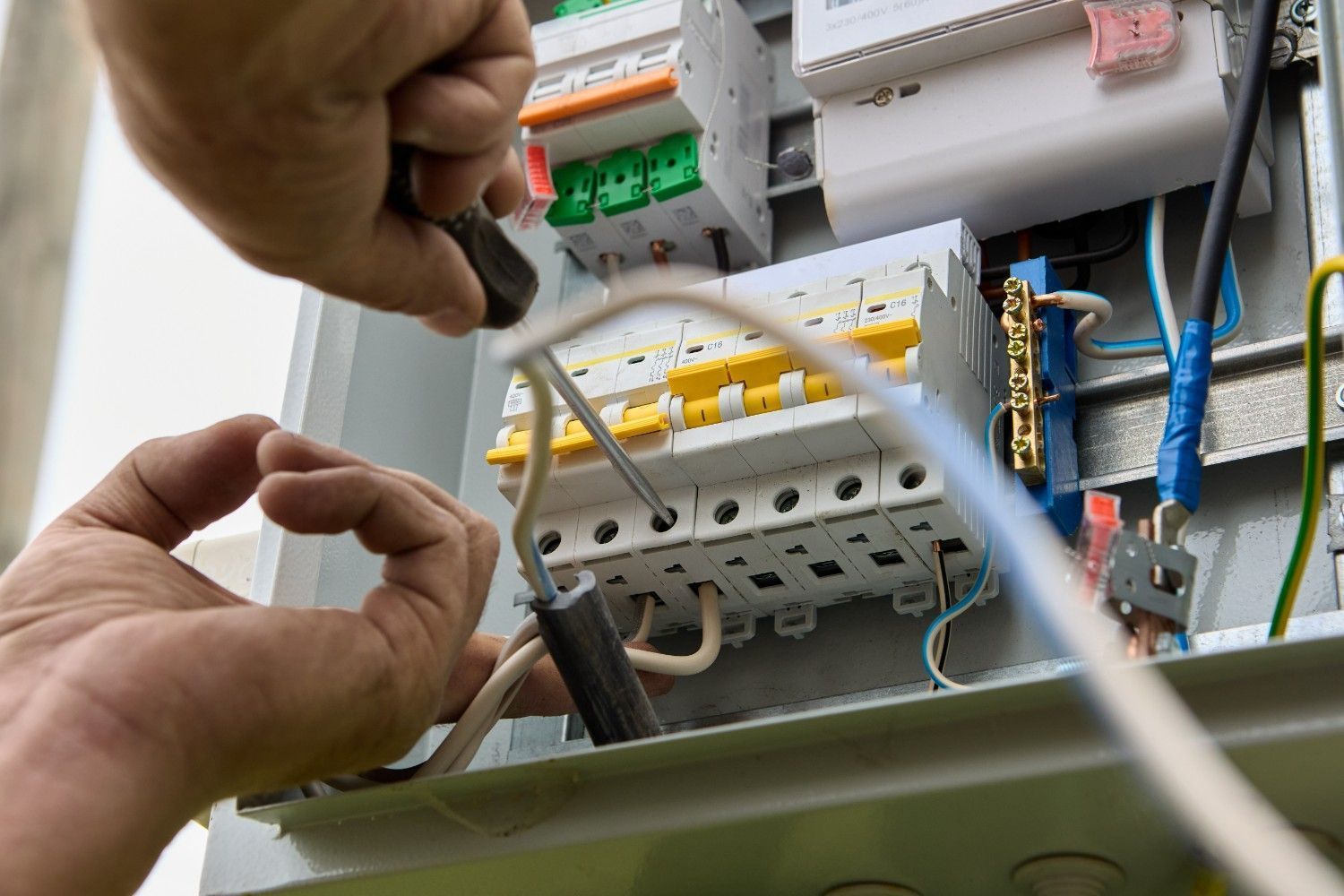 Person Using a Screwdriver to Work on Electrical Wiring in a Breaker Box — Russell Taber Electrical & Solar in Lake Albert, NSW
