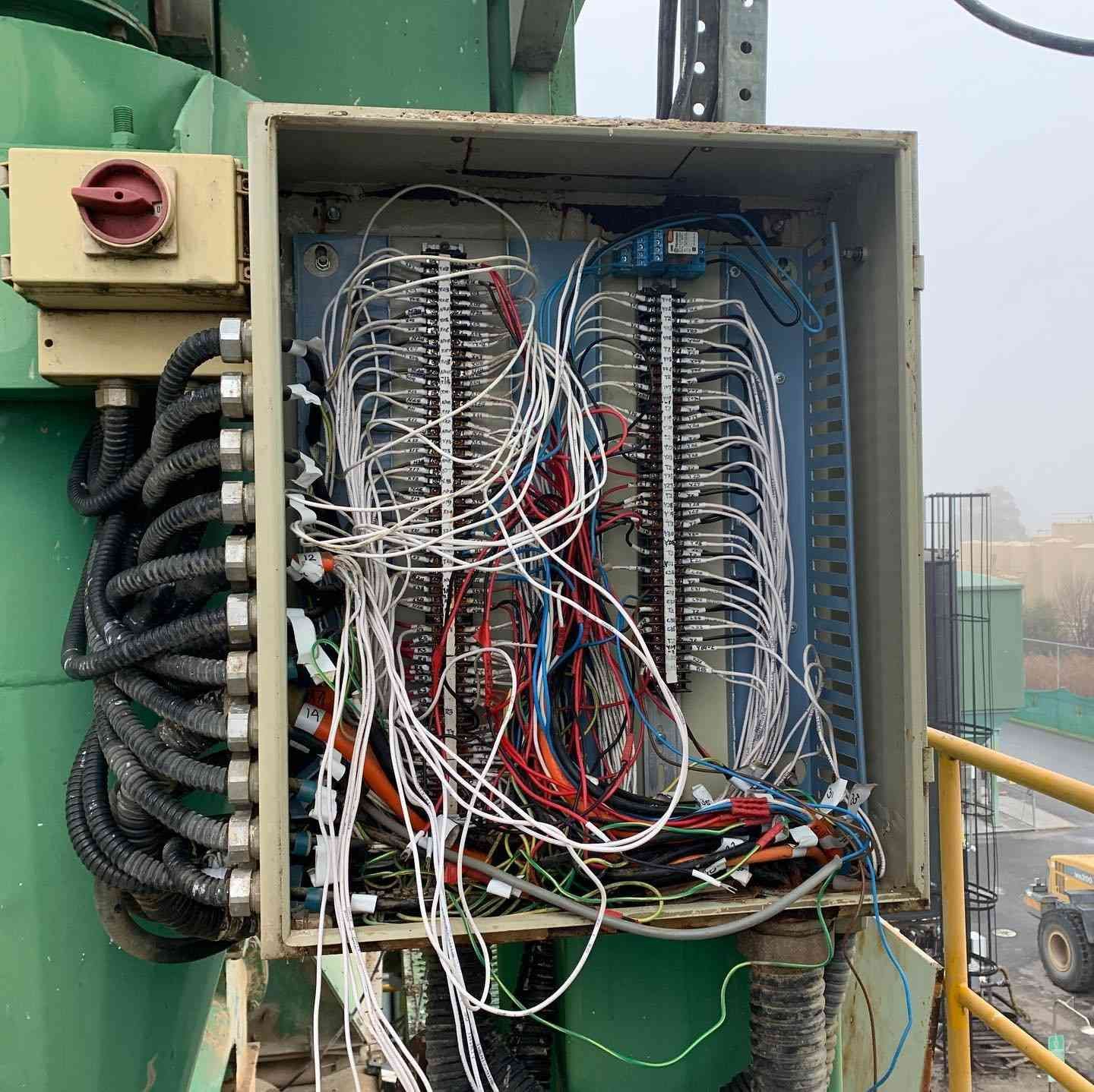 Open Electrical Panel With Tangled Wires and Terminals, Mounted Outdoors on Machinery — Russell Taber Electrical & Solar in Lake Albert, NSW