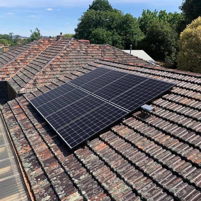 A Row of Solar Panels Are Sitting on Top of a Tiled Roof — Russell Taber Electrical & Solar in Lake Albert, NSW 