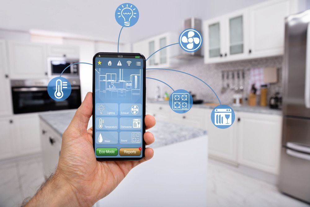 A Person is Holding a Smart Phone in Their Hand in a Kitchen — Russell Taber Electrical & Solar in Lake Albert, NSW