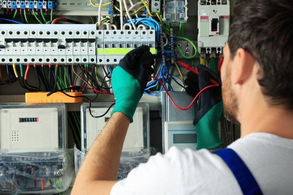 A Man is Working on an Electrical Panel With a Voltmeter — Russell Taber Electrical & Solar in Lake Albert, NSW