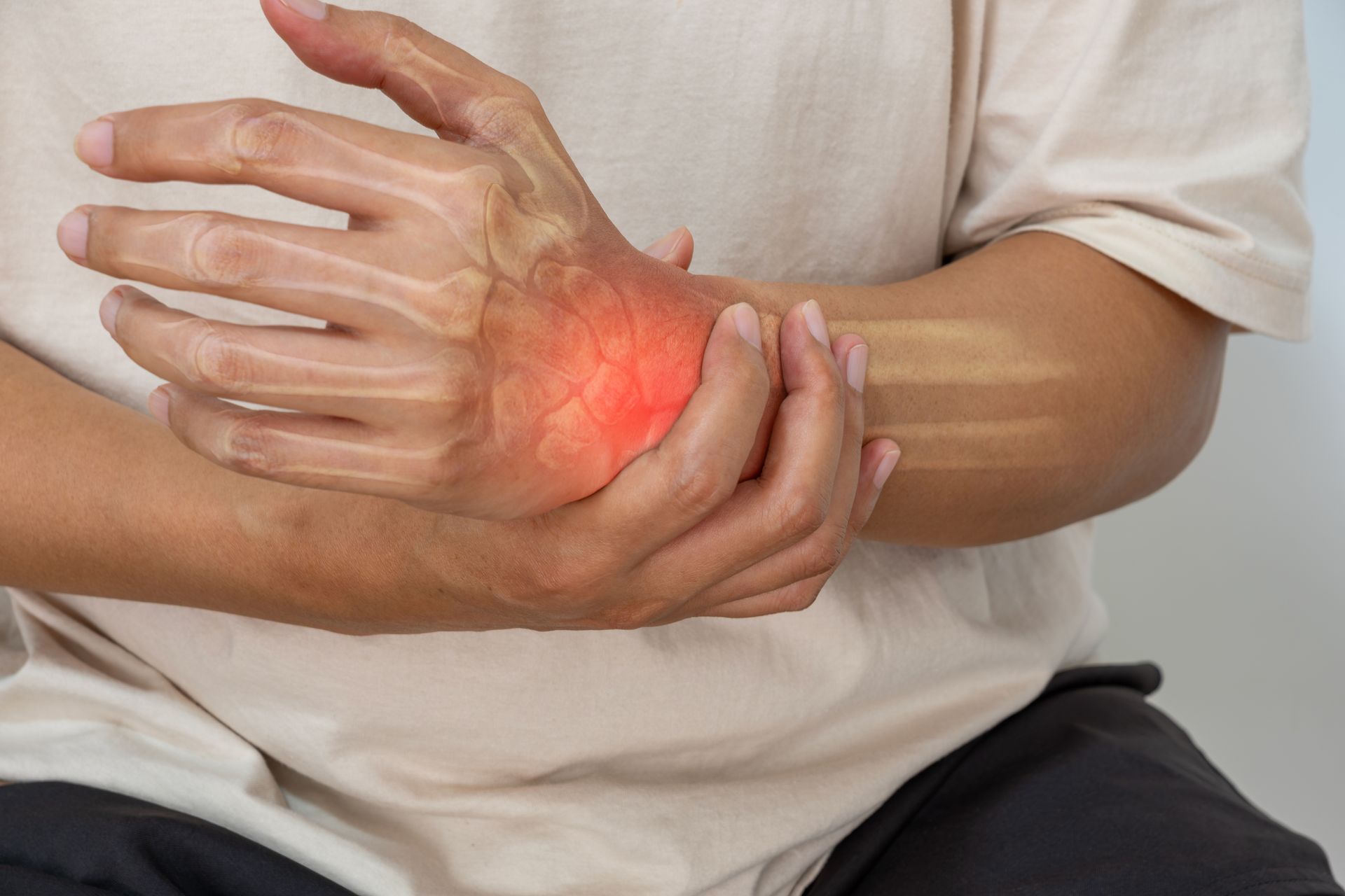 Person holding a painful wrist with red glow indicating pain or injury