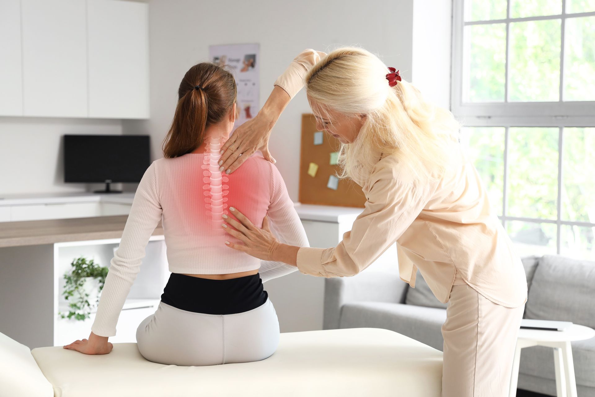 Physical therapist helping seated client stretch arm in a bright clinic room