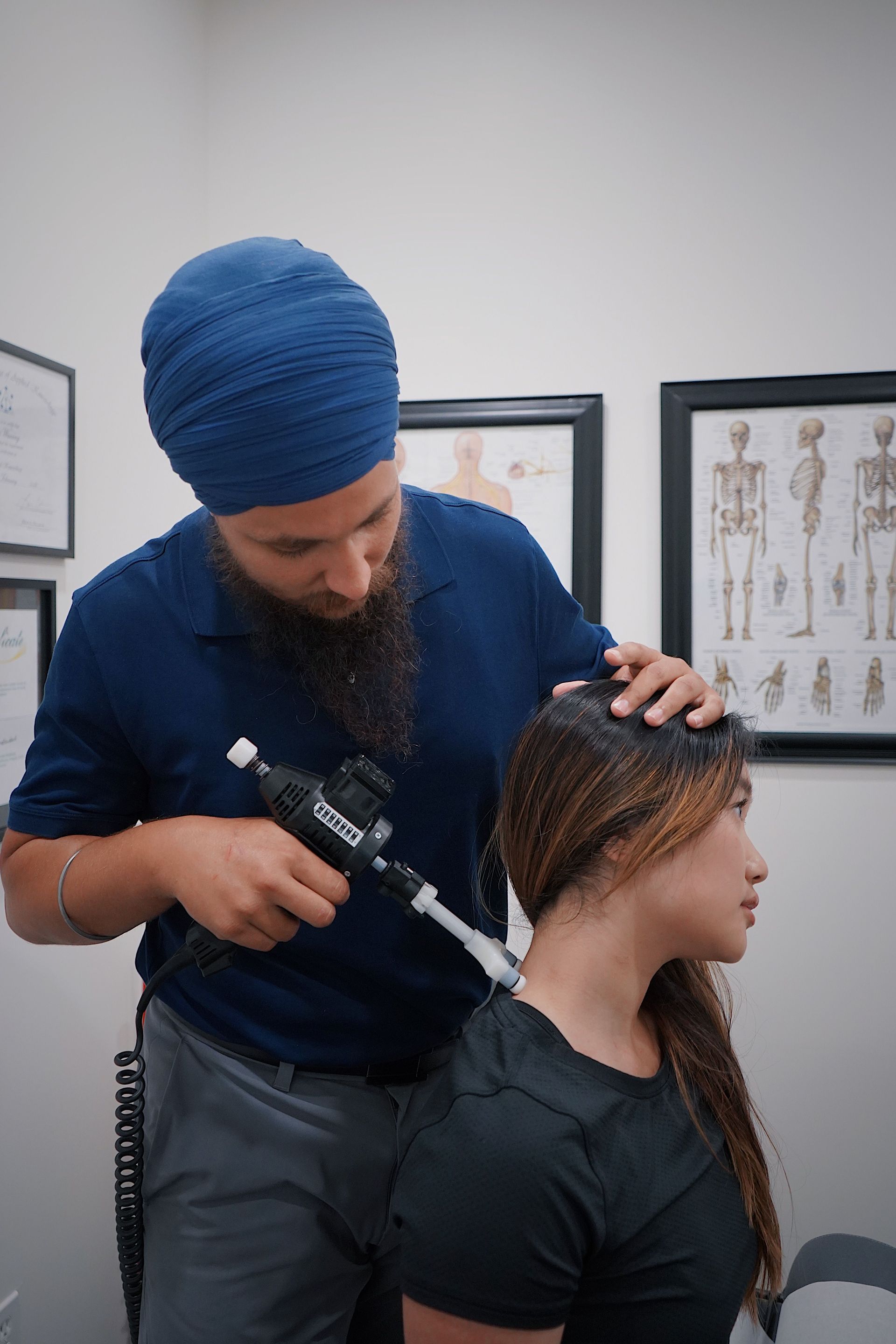 Hairdresser styling a client’s braids with a curling tool in a salon