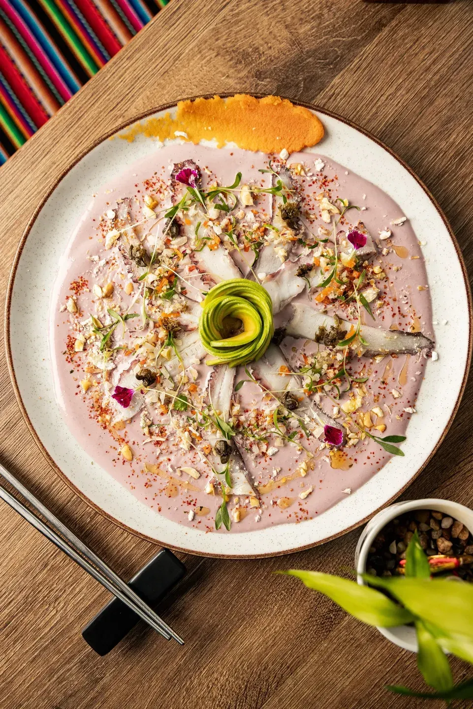Nikkei tiradito with avocado rose, red onion and edible flowers at Enkai.