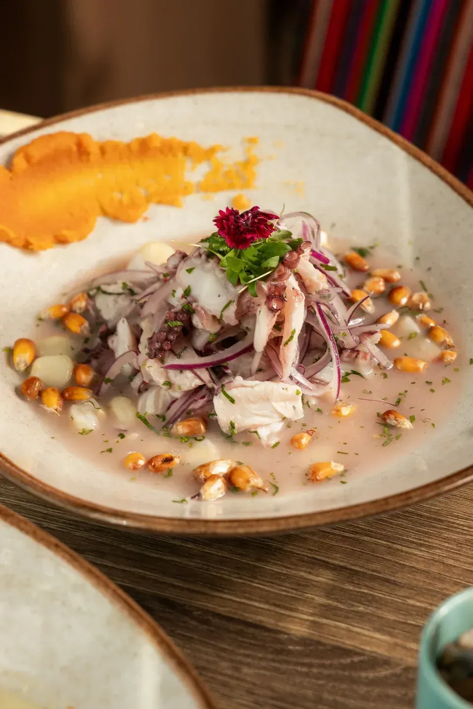 Ceviche-style fish with red onion, corn and edible flowers at Enkai.