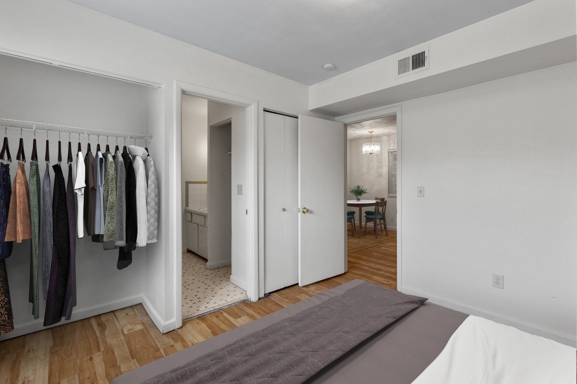 Bedroom with hardwood floors, closet, and bathroom; full-sized bed is for example only.