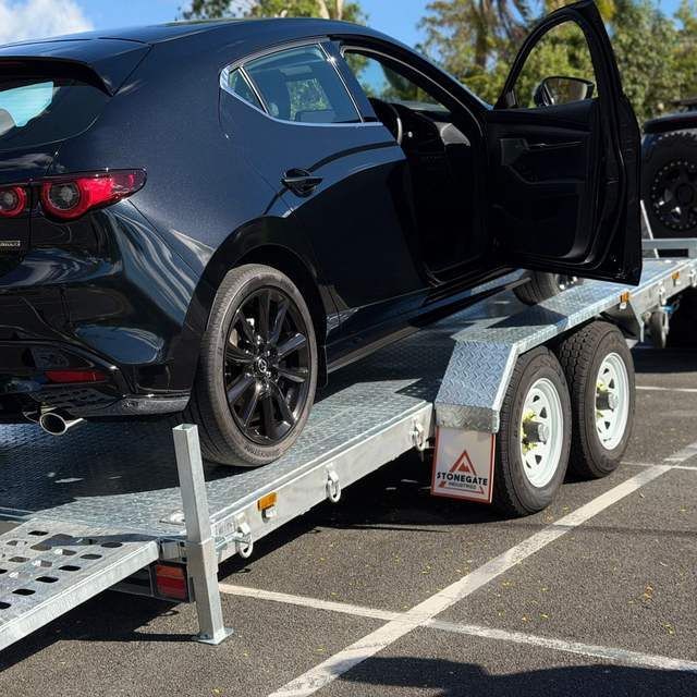 Black hatchback loaded on the TrailerMates hydraulic tilt car trailer