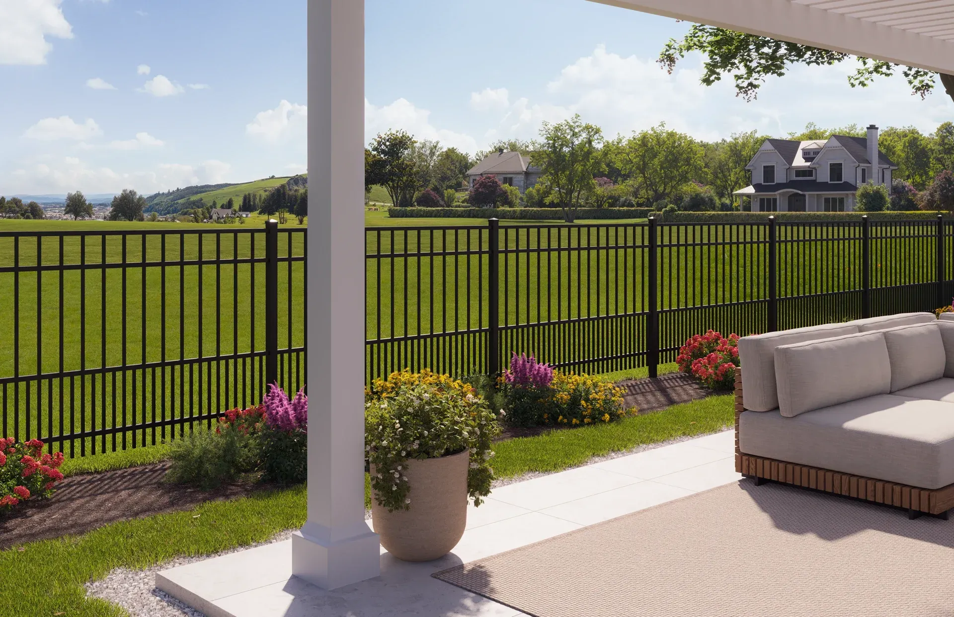 Patio with outdoor seating, lawn, black fence, and view of houses.