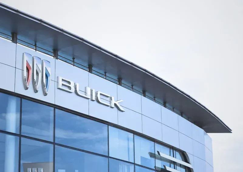 Buick dealership building exterior with logo on a curved glass facade