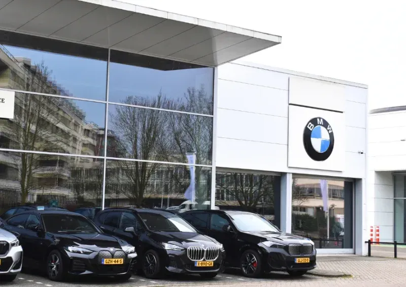 BMW dealership exterior with several black cars parked in front