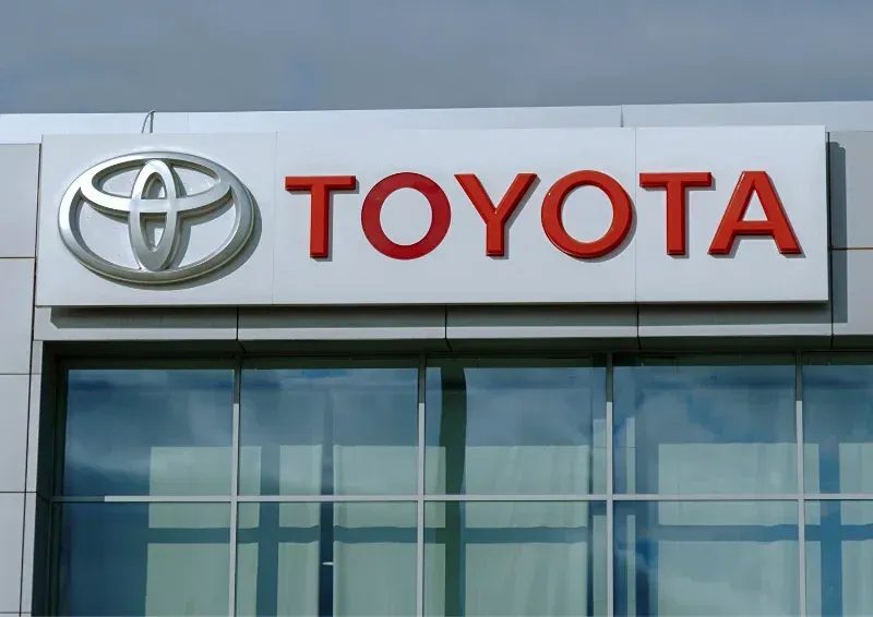 Toyota dealership sign on a building with the silver logo and red Toyota lettering