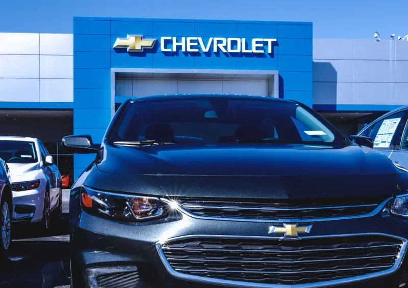 Black Chevrolet SUV parked at a Chevrolet dealership storefront