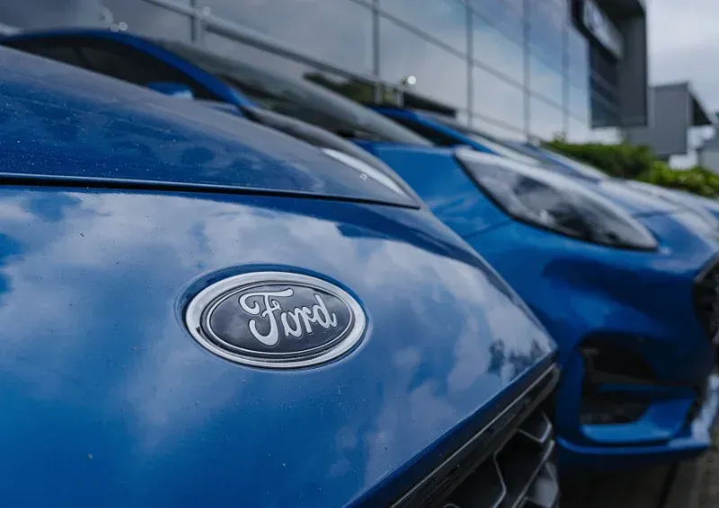 Blue Ford cars lined up outside a dealership