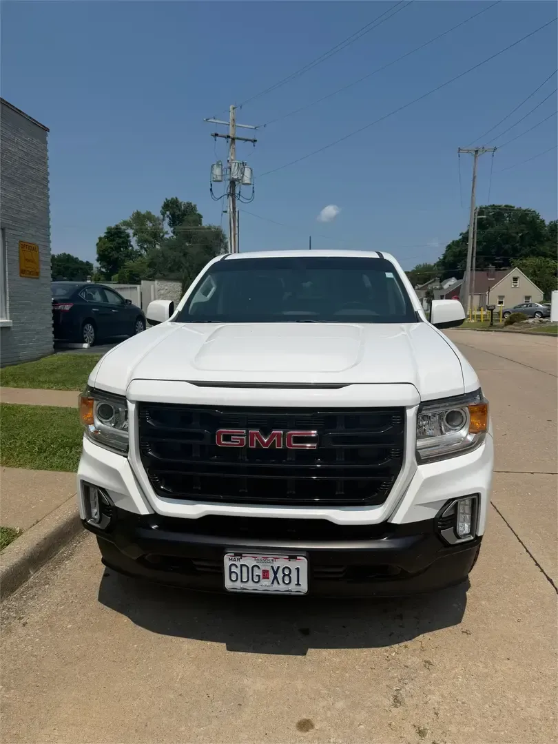 Close-up of a black GMC truck grille with chrome logo