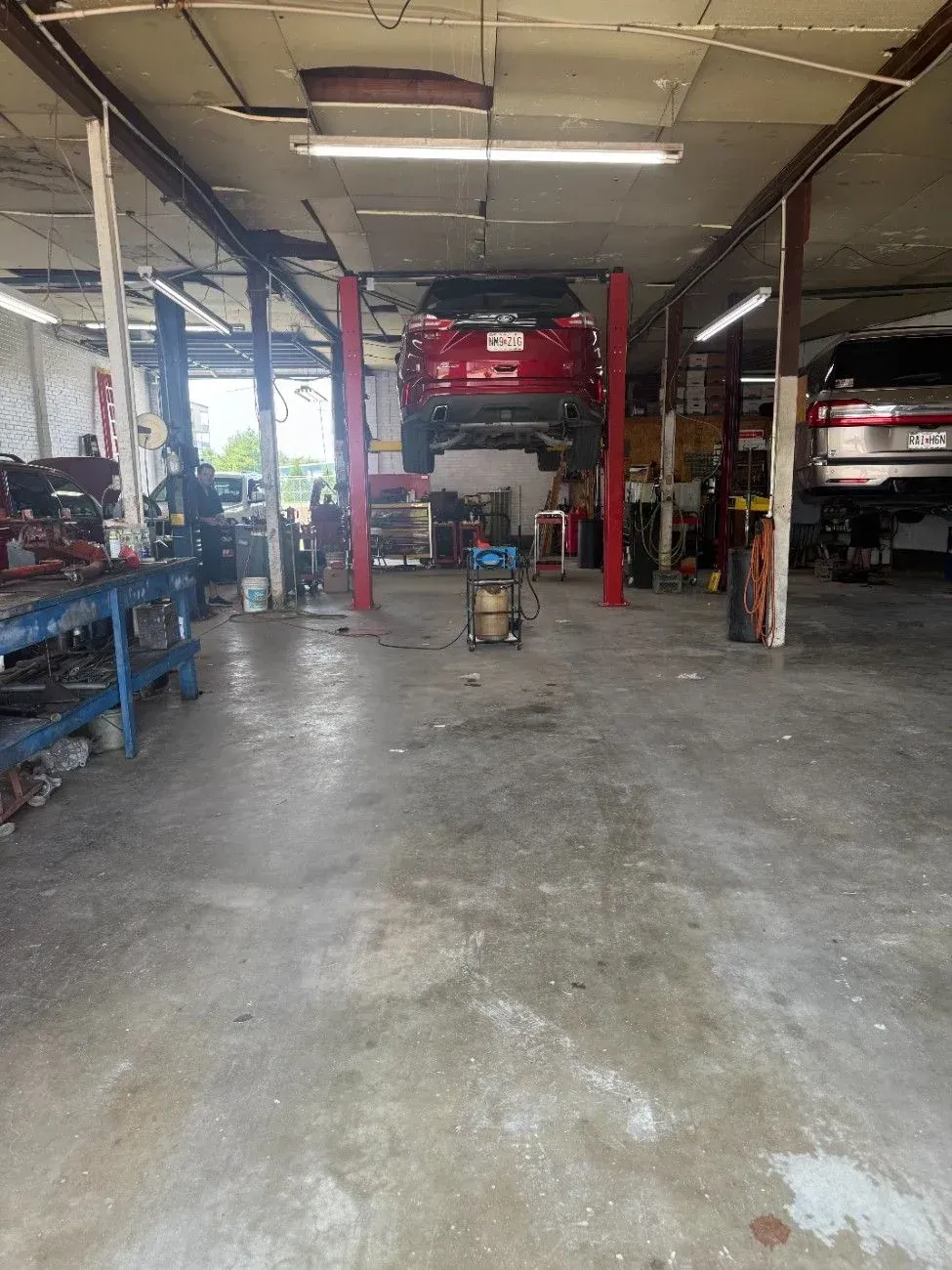 Auto repair shop in Cape Girardeau, MO interior with vehicles on lifts and a concrete floor