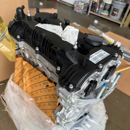 Wrapped black engine component on a pallet in a warehouse, with orange protective cover underneath