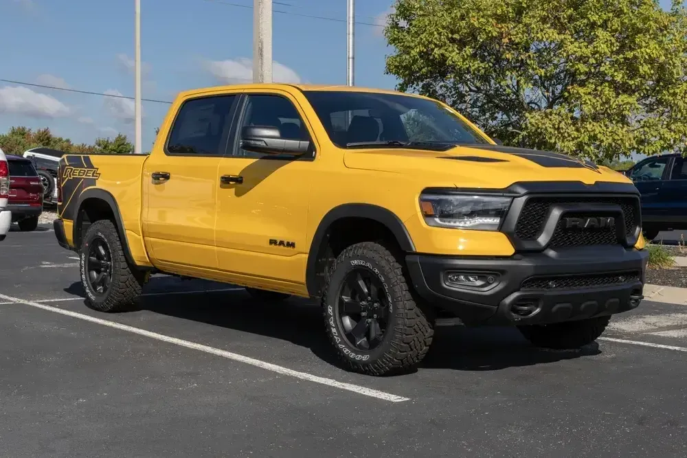 Yellow pickup truck parked in a lot on a sunny day