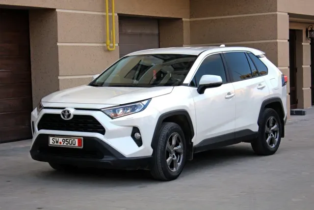 White Toyota SUV parked beside a building, front-left view, with black trim and tinted windows