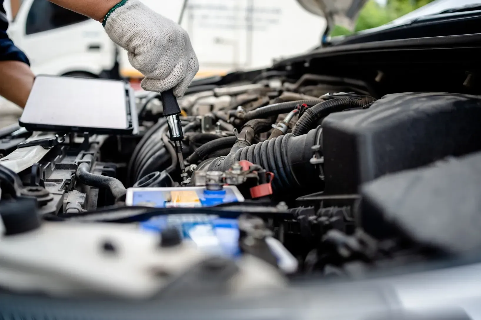 Gloved mechanic working on a car engine in an open hood bay in Cape Girardeau, MO