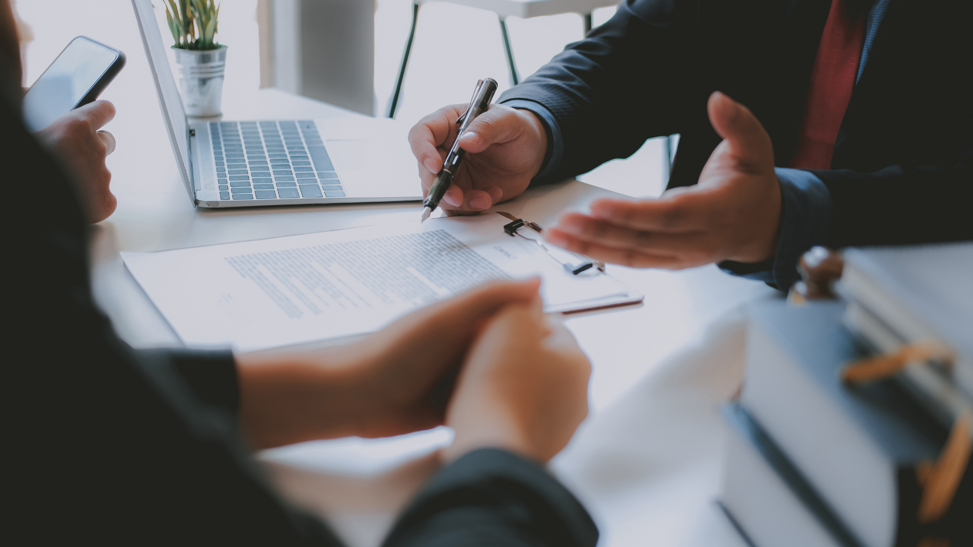 A man and a woman are sitting at a table signing a document.