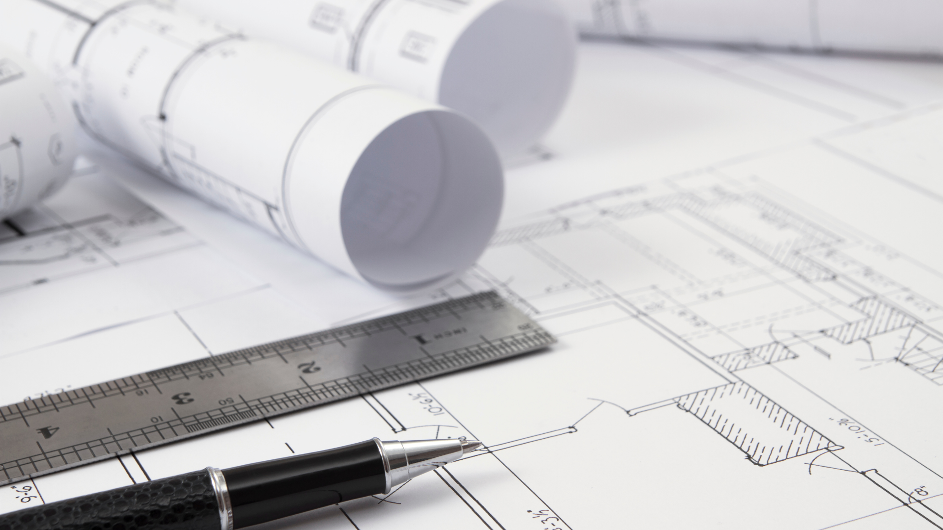 A pen is sitting on top of a drawing next to a ruler.