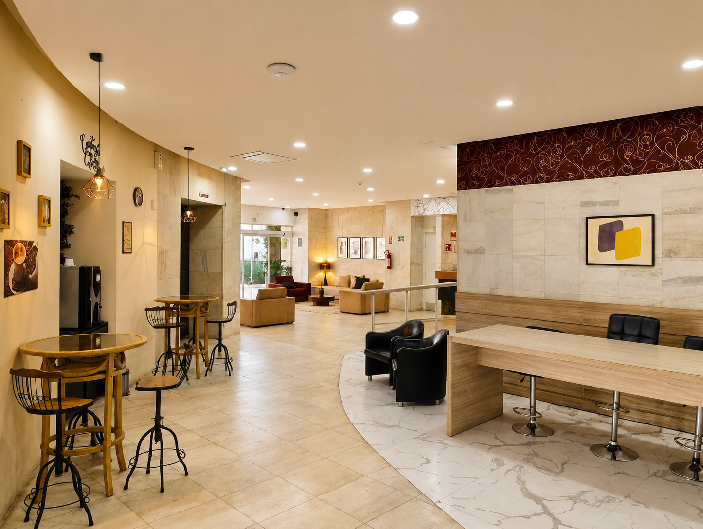 Hall de entrada de hotel moderno com sofás bege, tapete preto, obras de arte emolduradas e decoração com detalhes em vermelho.